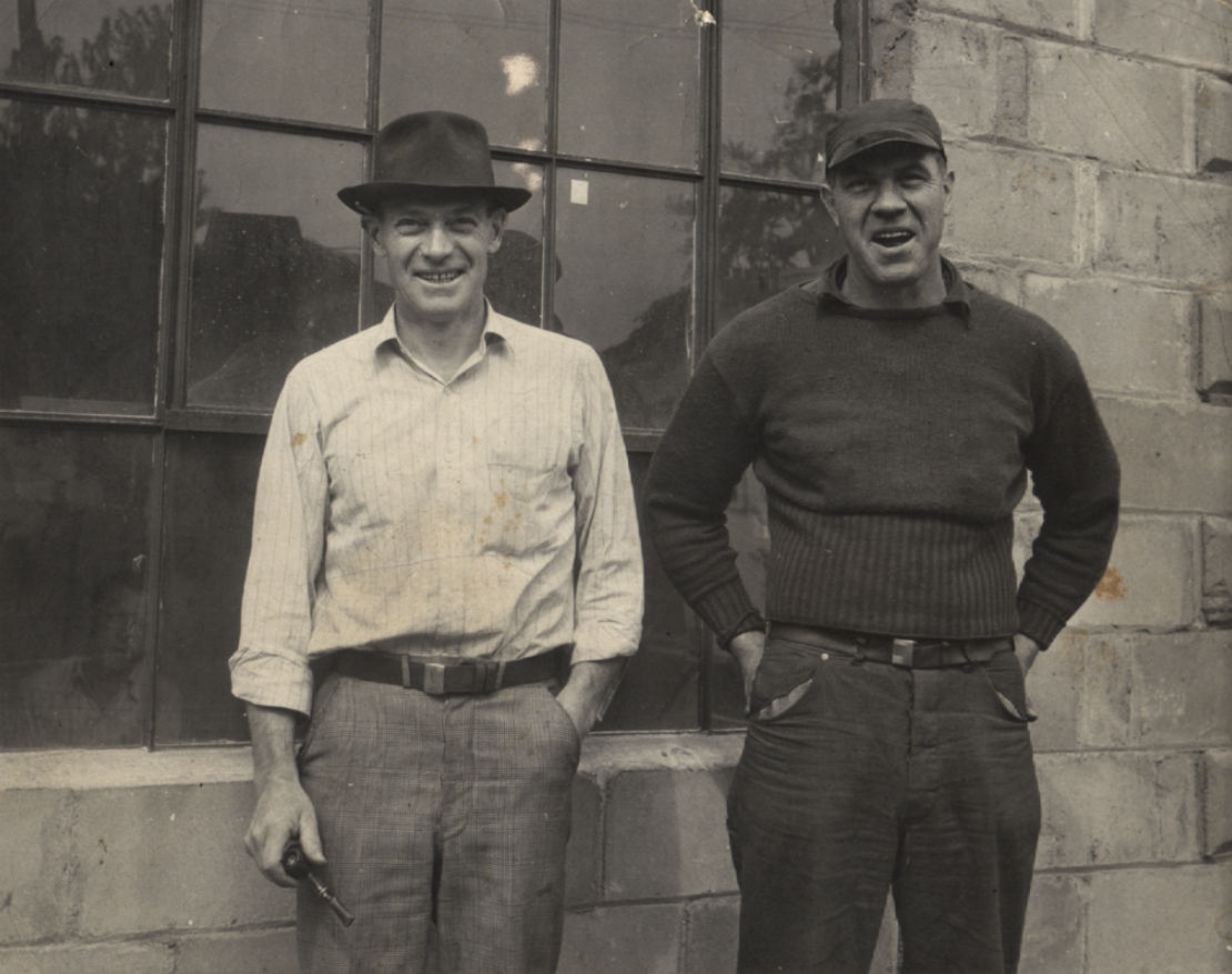 Valencia photo of Norman E. Warner and Vernon E. Warner standing outside a brick building