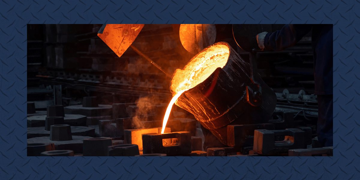Glowing molten alloy pours from a large crucible into a mold in a dark metal foundry surrounded by numerous casting forms on the floor.